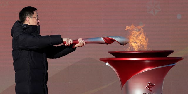 Chinese Vice Premier Han Zheng lights the torch before the start of the torch relay for the 2022 Winter Olympics at the Olympic Forest Park in Beijing on Wednesday, Feb. 2, 2022. 